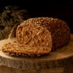 un pain de petit épeautre recette avec peu de calories, tranché sur une planche en bois.